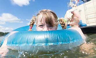 Kinder baden an der Mecklenburgischen Seenplatte direkt vom Hausboot