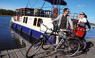Ein Paar hat seine Fahrräder vom Hausboot geholt und will eine Radtour unternehmen.