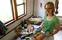 Eine junge Frau bereitet fröhlich ein Essen auf ein Hausboot zu.