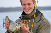 Ein glücklicher Angler mit einem Fisch in der Hand